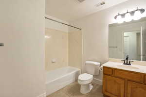 Bathroom featuring vanity, shower / bathtub combination, and light tile patterned flooring
