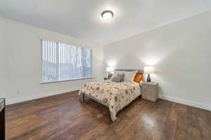 Bedroom with dark wood-type flooring and a textured ceiling