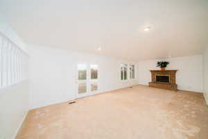 Unfurnished living room with a fireplace, carpet flooring, and recessed lighting