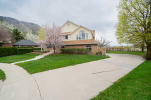 View of front of property with brick siding, a front lawn, and concrete driveway