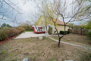 Fenced backyard with a wooden deck and a patio area