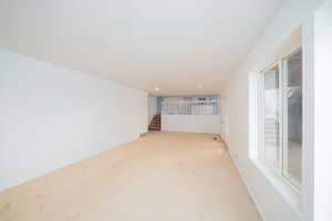 Unfurnished living room with stairway and carpet floors