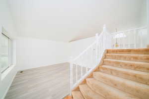 Staircase featuring wood finished floors