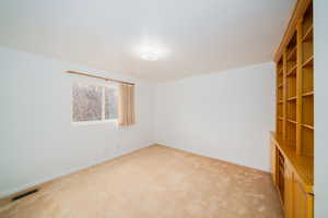 Carpeted empty room featuring baseboards