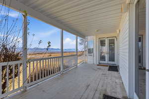 Wooden terrace featuring french doors and a mountain view