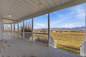 Deck featuring a view of countryside, a mountain view, and a yard