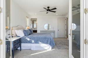 Bedroom with carpet floors, a ceiling fan, ensuite bathroom, and recessed lighting