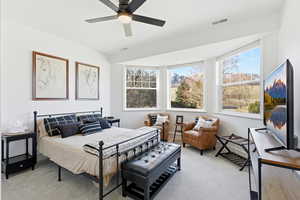 Carpeted bedroom featuring a ceiling fan