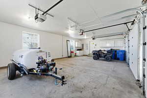 Garage featuring a garage door opener and electric panel