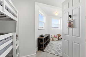 Doorway featuring carpet floors and baseboards