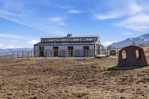 Back of property with a mountain view, an exterior structure, an outbuilding, and a metal roof
