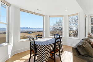 Dining room with light wood-type flooring, a mountain view, and recessed lighting