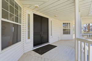 Entrance to property featuring covered porch and french doors