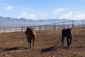 Surrounding community with a mountain view and an enclosed riding area