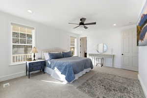 Carpeted bedroom featuring a ceiling fan and recessed lighting