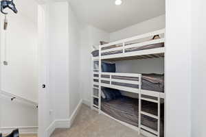 Unfurnished bedroom with light carpet and recessed lighting