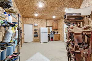 Kitchen with wood finish cabinetry, freestanding refrigerator, concrete flooring, and recessed lighting