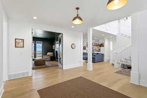 Foyer with light wood finished floors and recessed lighting