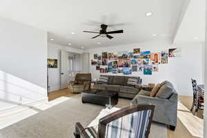 Living room with a ceiling fan, recessed lighting, and light wood finished floors