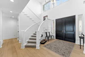 Foyer featuring light wood-style flooring, a high ceiling, and recessed lighting