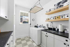 Laundry room featuring cabinet space, light floors, and washing machine and clothes dryer