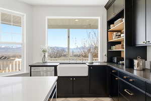 Kitchen featuring dark cabinetry, dark countertops, a mountain view, open shelves, and dishwasher