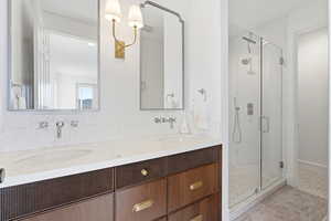 Bathroom featuring a shower stall and double vanity