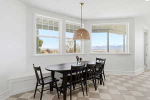 Dining space with light floors, a mountain view, and healthy amount of natural light