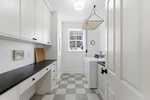 Laundry area featuring cabinet space, light flooring, and hookup for an electric dryer