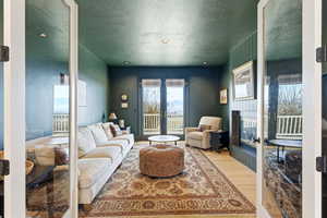 Living room featuring a textured ceiling, wood finished floors, a glass covered fireplace, and recessed lighting