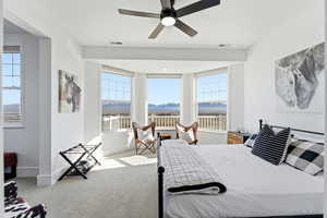 Carpeted bedroom with ceiling fan and a mountain view