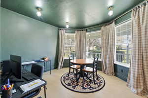 Dining space with a textured ceiling, a desk, and light wood finished floors