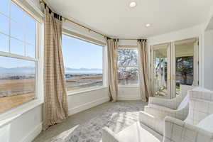 Sunroom with a mountain view, recessed lighting, french doors, and carpet