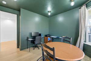 Dining area with a desk and light wood-style flooring