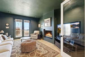 Living room with wood finished floors, a textured ceiling, a large fireplace, and recessed lighting