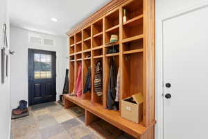 Mudroom featuring stone finish flooring and recessed lighting