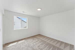 Empty room featuring light carpet and baseboards