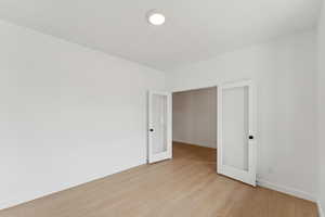 Unfurnished bedroom featuring light wood finished floors and french doors