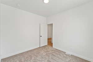 Spare room with baseboards and carpet floors
