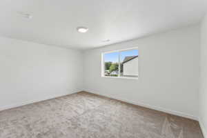 Unfurnished room featuring light colored carpet and baseboards