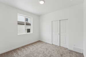 Unfurnished bedroom featuring a closet and light carpet