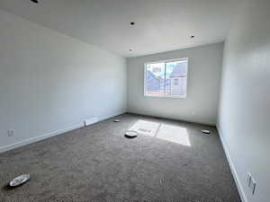 Carpeted spare room with baseboards