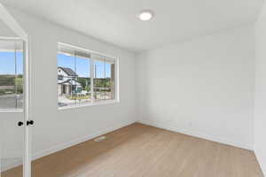 Empty room with light wood finished floors and baseboards