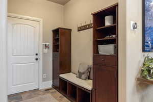Mudroom with stone finish floors and baseboards