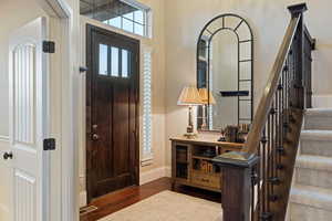 Foyer entrance with stairway and dark wood finished floors