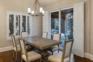 Dining area with hanging lights and dark wood finished floors