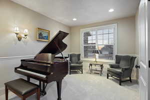 Sitting room featuring light colored carpet, recessed lighting, a textured ceiling, and a wainscoted wall