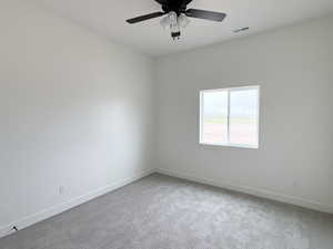 Empty room with light carpet and a ceiling fan