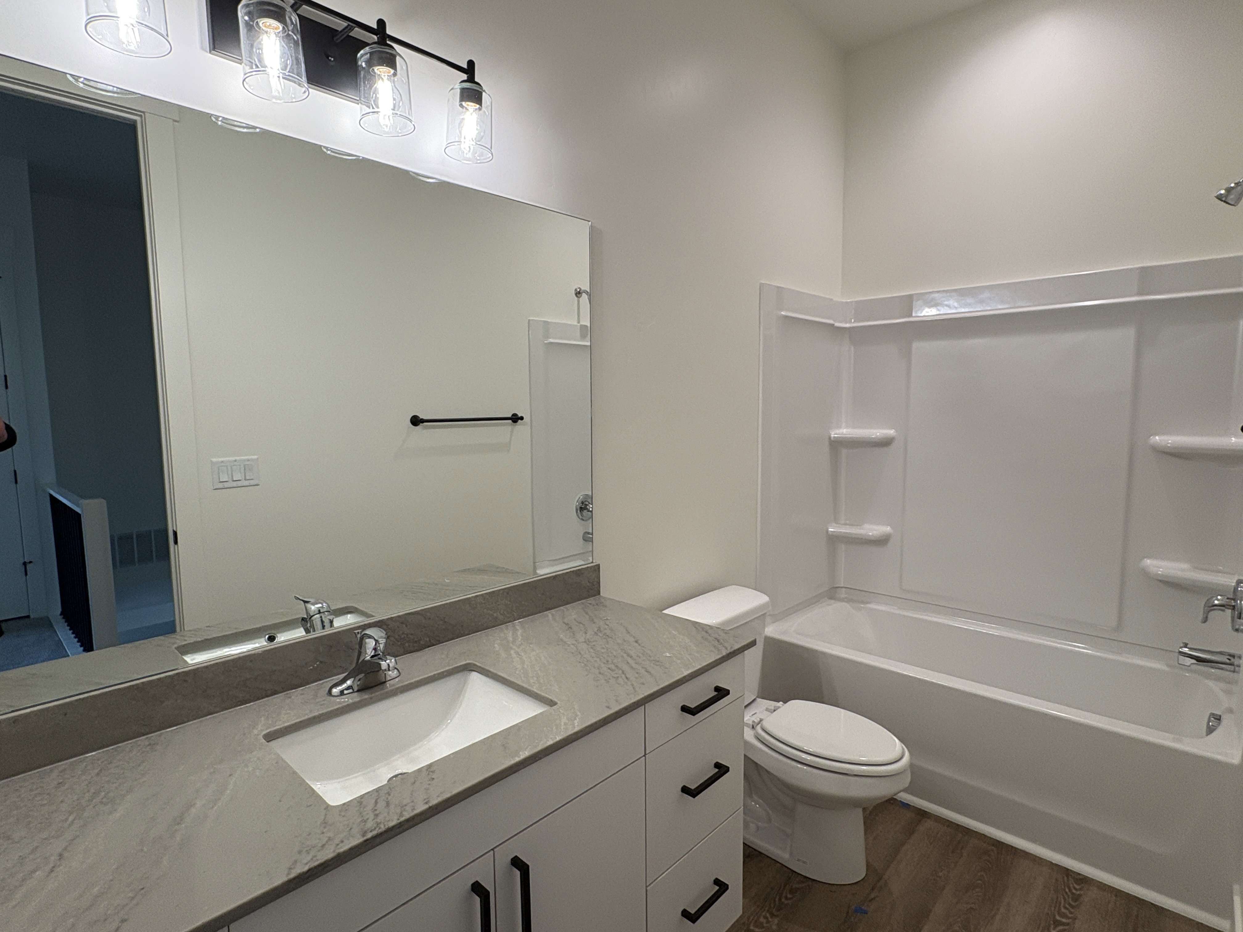 Full bath with vanity, shower / washtub combination, and dark wood-style floors