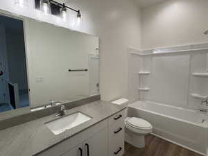 Full bath with vanity, shower / washtub combination, and dark wood-style floors